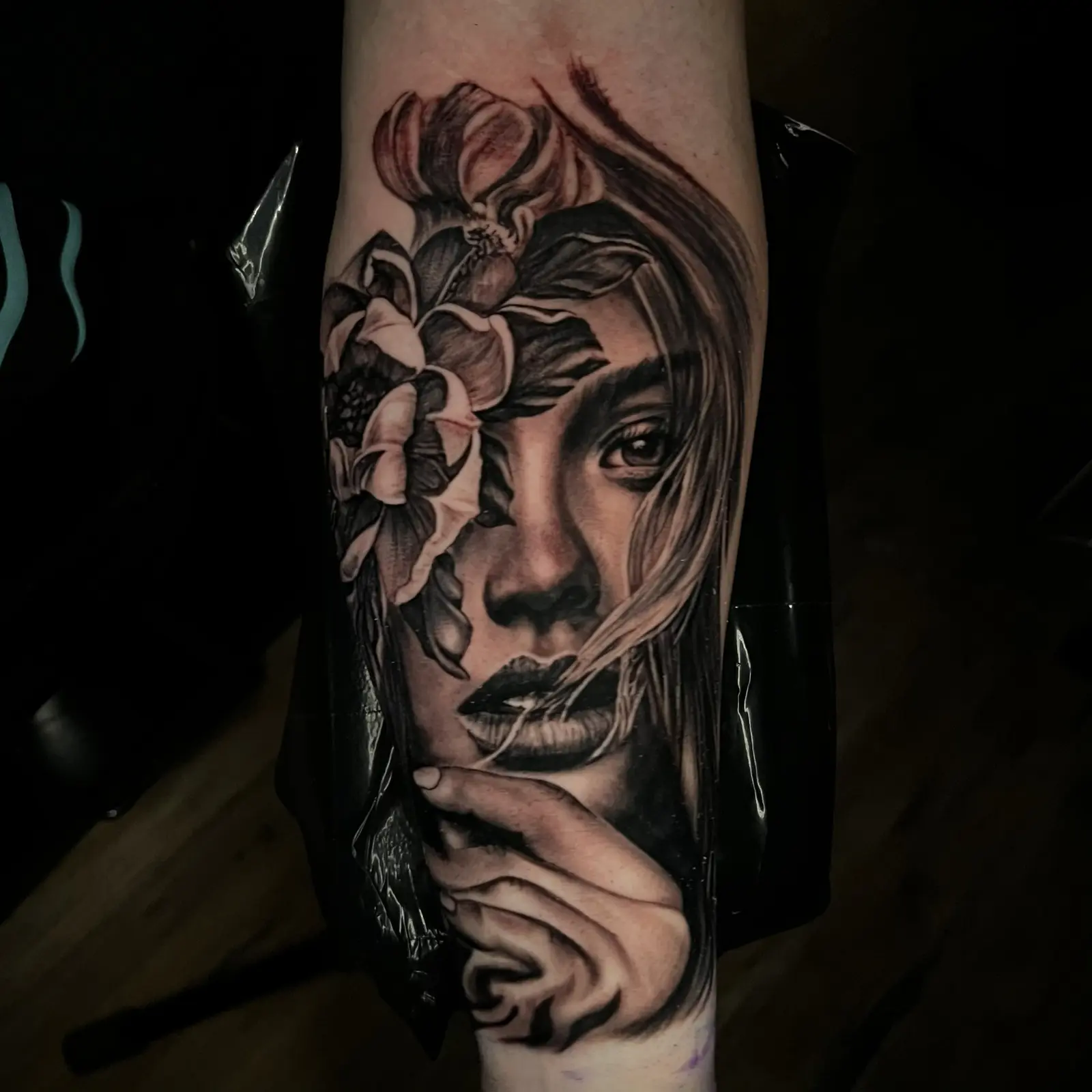 Black and grey illustrative woman’s face with flowers and ornamental linework