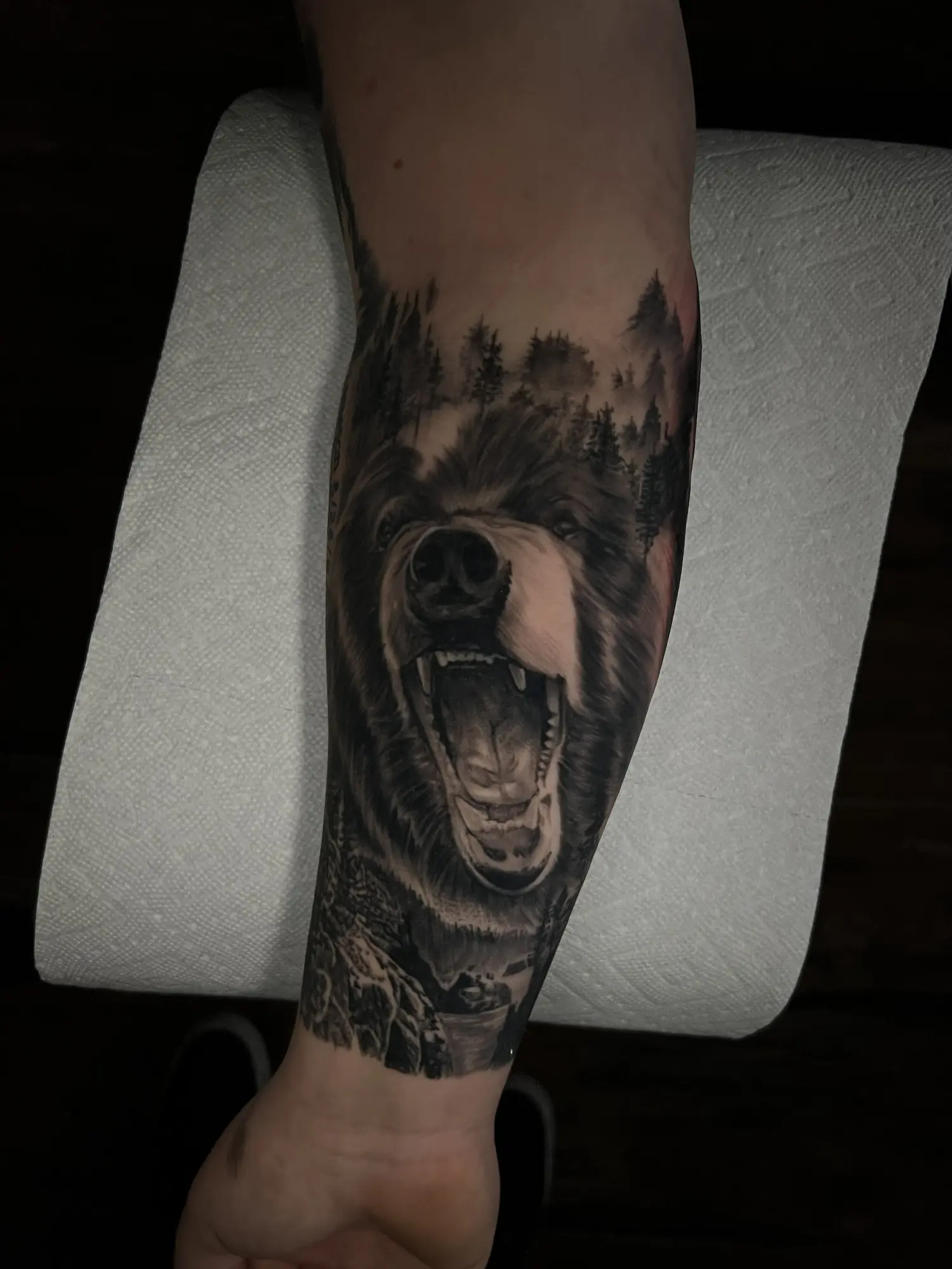 Black and grey screaming face and forest forearm tattoo