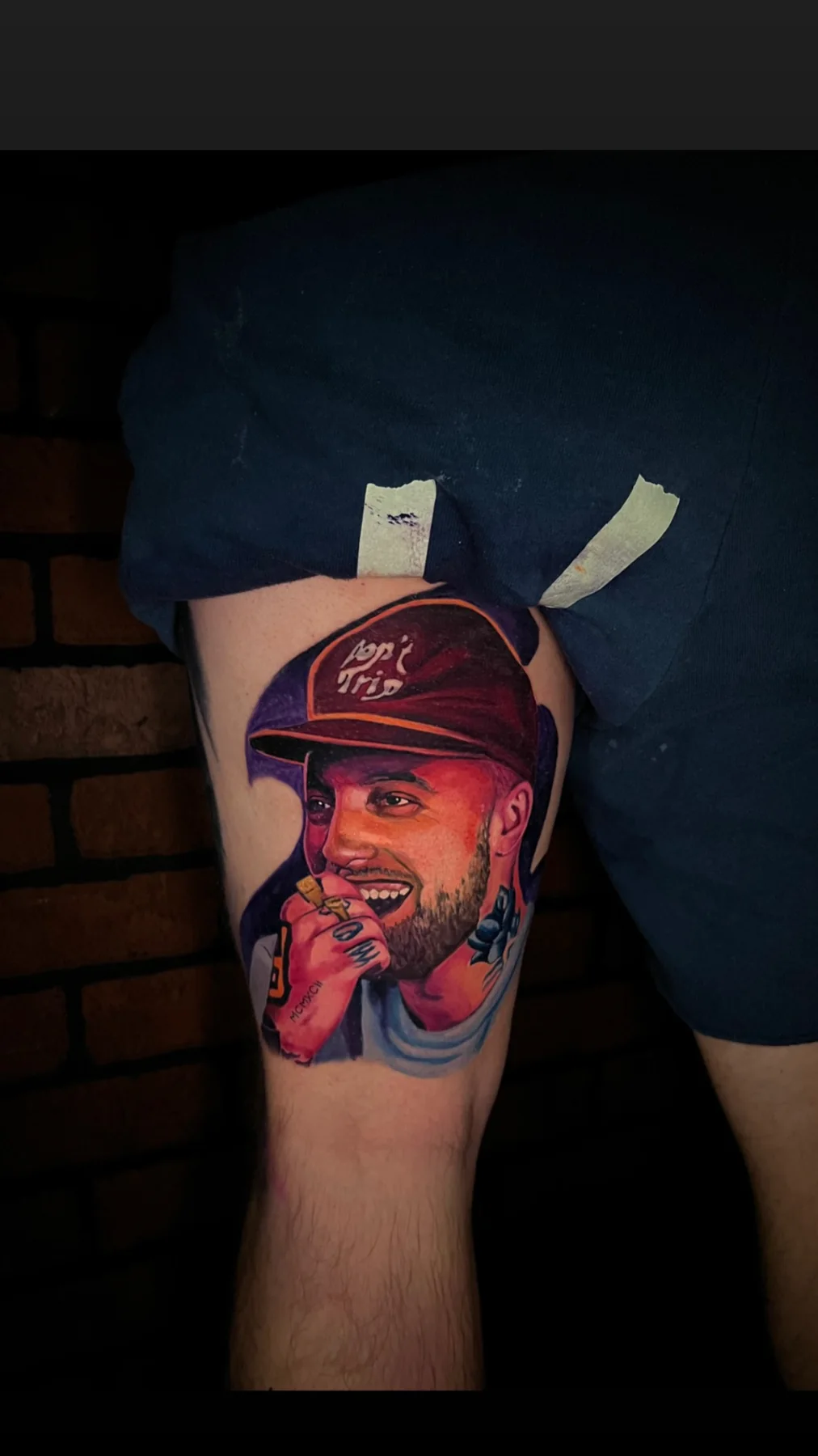Color portrait tattoo of a smiling man in a red cap