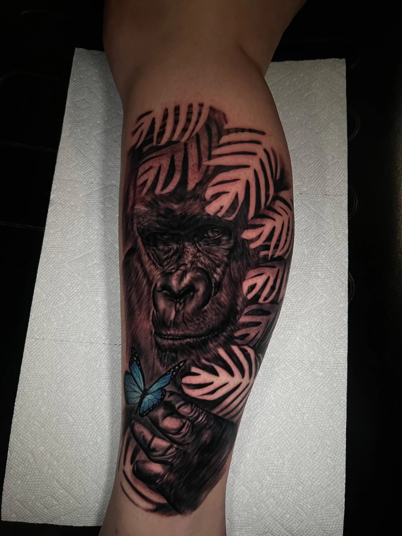 Black and grey gorilla tattoo with blue butterfly accent