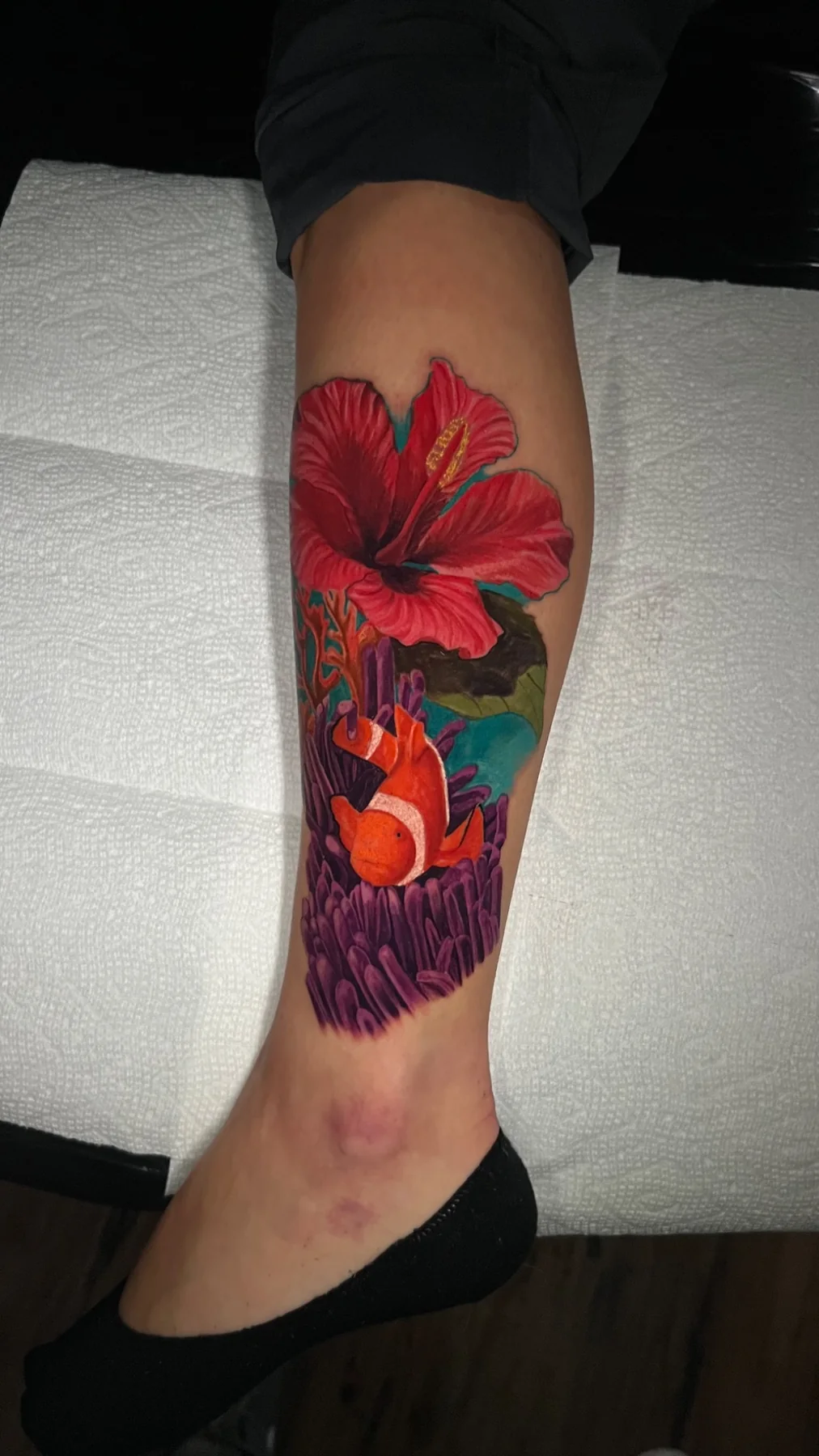 Color realism clownfish, hibiscus, and coral tattoo