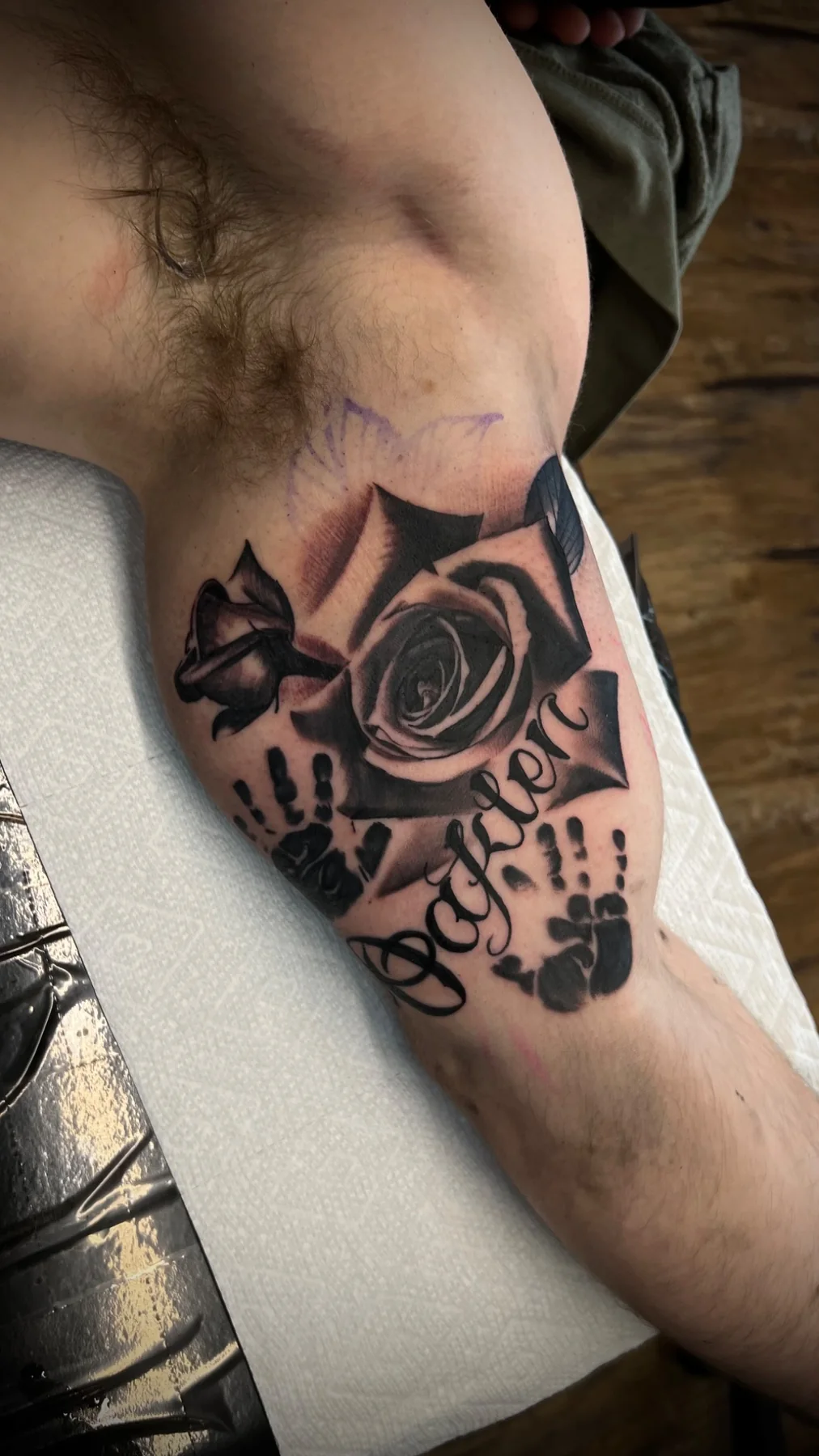 Black and grey rose memorial tattoo with handprints and script