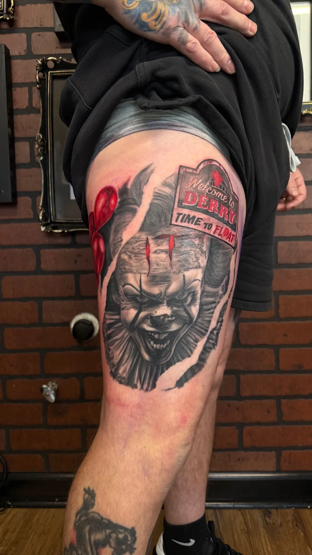 Black and grey horror clown tattoo with red accents