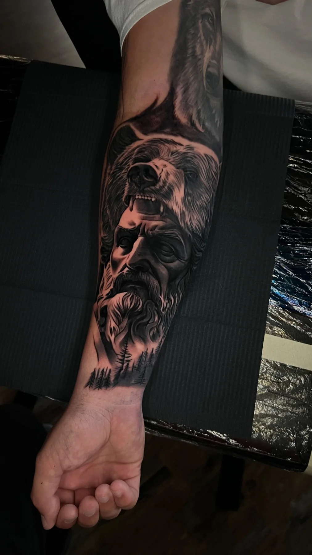 Black and grey realism bear and bearded-man sleeve tattoo