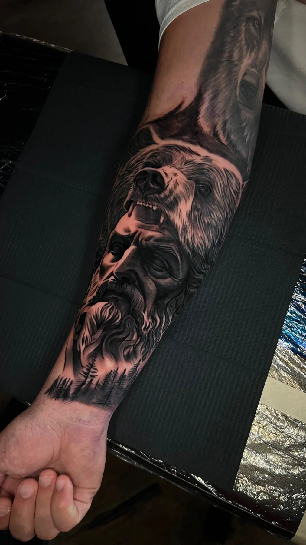 Black and grey realism bear and bearded-man sleeve tattoo, alternate view